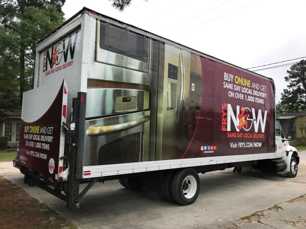 A maroon truck featuring a prominent advertisement on its side, catching eyes with its vibrant display.