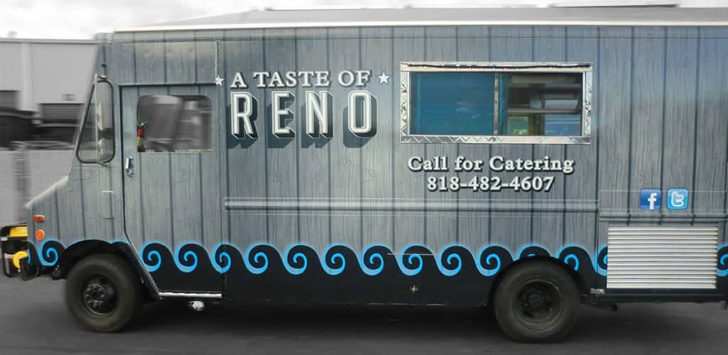Catering truck with a gray and blue wrap.