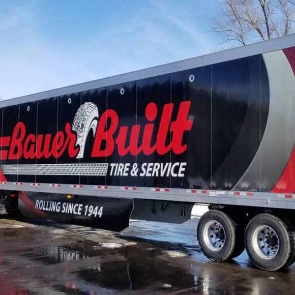 A semi truck with a trailer displaying the text "Bauer Built".