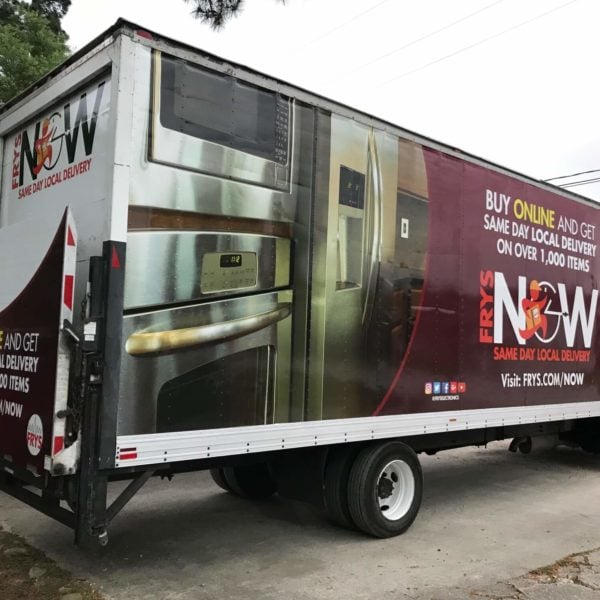 Image of a maroon box truck wrapped with a big advertisement.