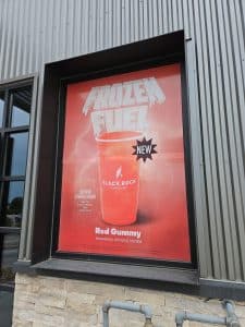 A sign on a building promoting frozen fuel, clearly visible and designed to attract attention from passersby.