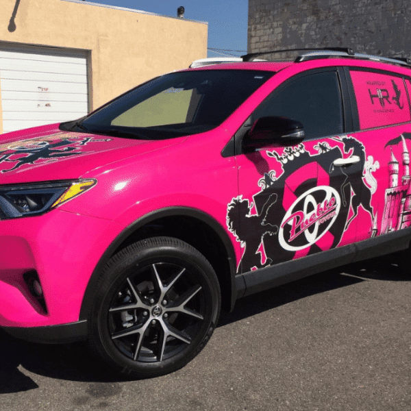 A pink Toyota RAV4 featuring a vibrant pink paint job, showcasing a stylish car wrap design.