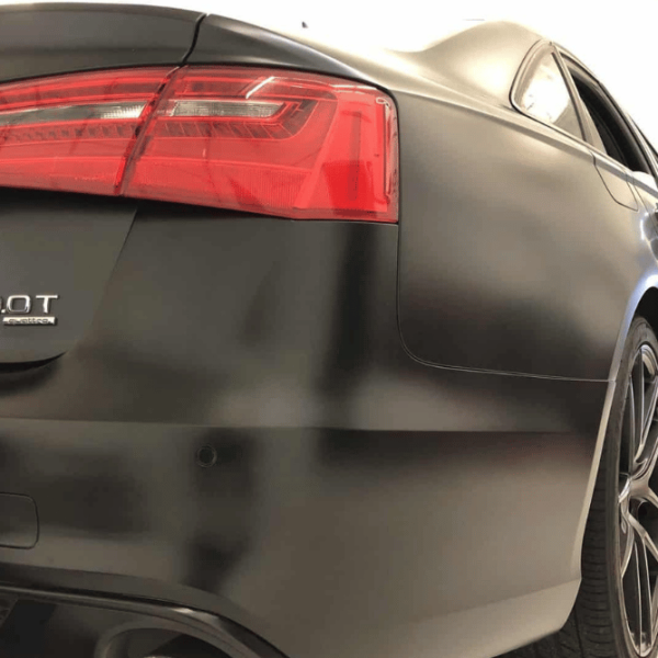 A black vinyl-wrapped Audi S4, emphasizing its elegant design and performance-oriented features.